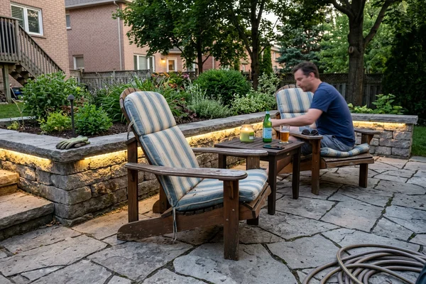 Backyard patio with accent lights on a stone retaining wall