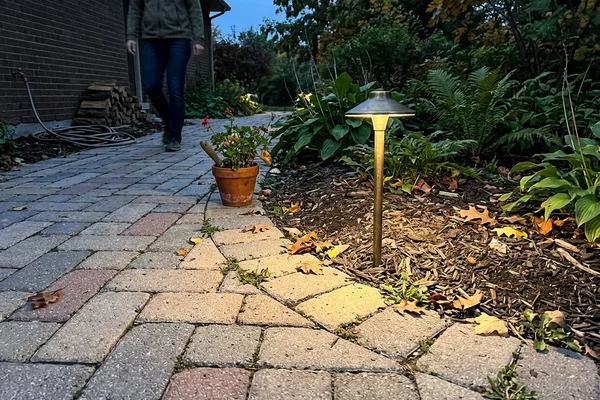 Brass LED path light beside an interlock walkway