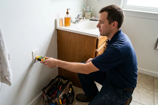 GFCI outlet being tested beside a bathroom vanity